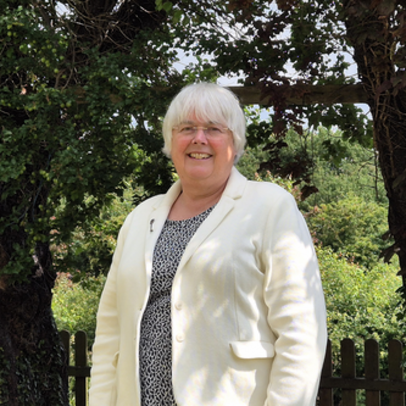 Charlotte Cane standing in front of some trees