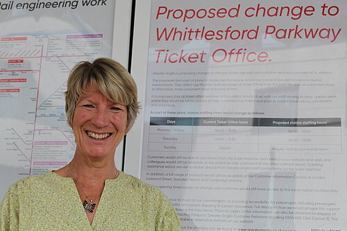 Pippa Heylings, Liberal Democrats parliamentary candidate for South Cambridgeshire, stands in front of an announcement about changes to the Whittlesford Parkway ticket office