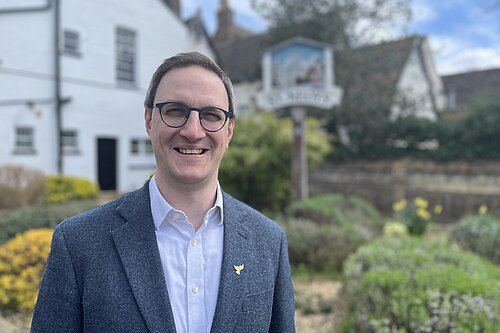 Ian near the river in St Neots, with a decorative St Neots sign in the background